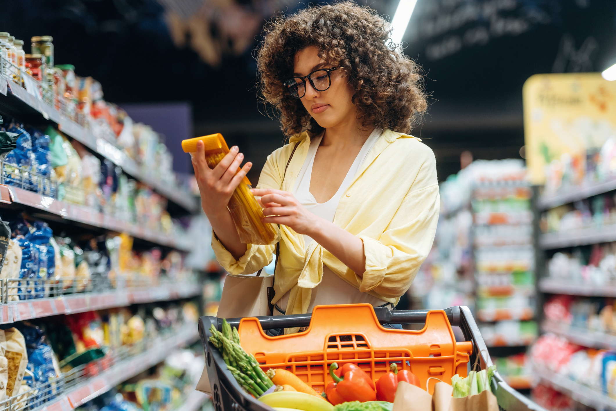 woman comparing prices at grocery store